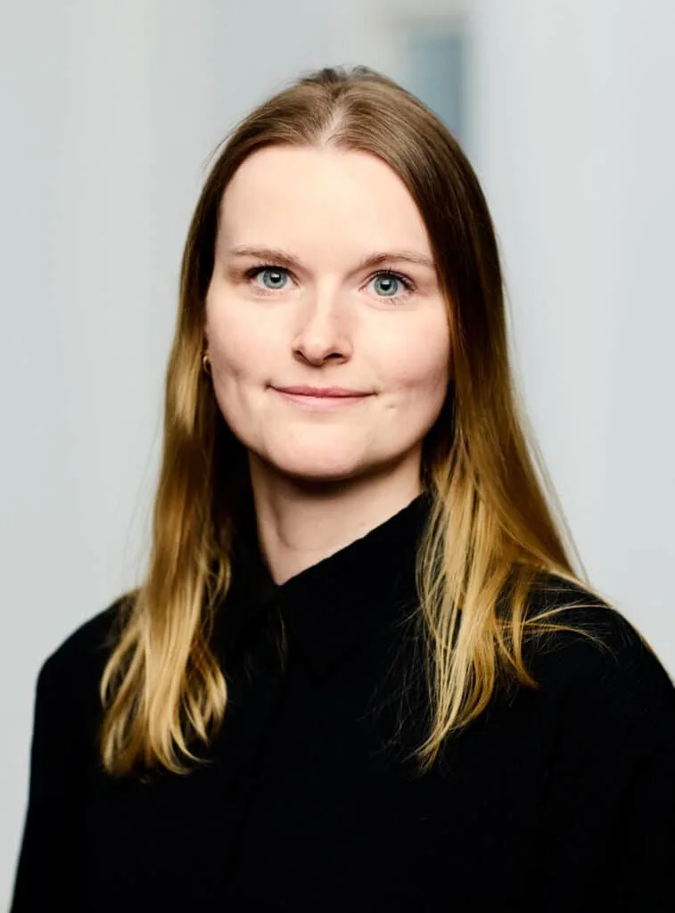 a woman with long blonde hair wearing a black shirt